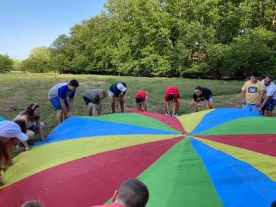Un grupo de participantes alzan un paracaidas de colores