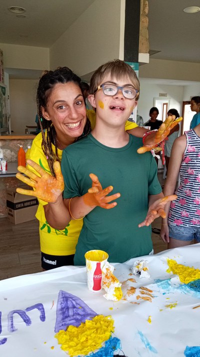 Un participante y una monitora pintando un mural