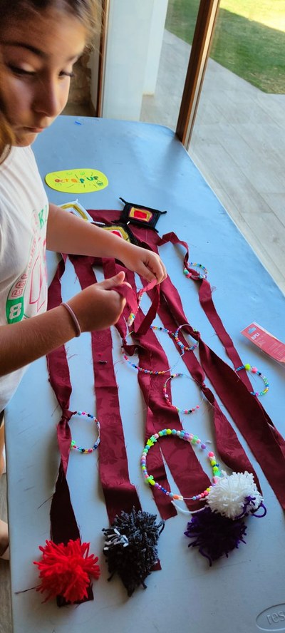 Una participantes expone unas pulseras hechas a mano