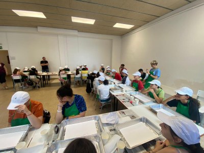 Los participantes sentados alrededor de una mesa preparados para crear su obra artística