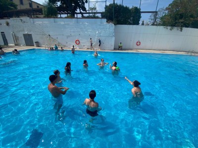Un grupo de participantes juegan en la piscina