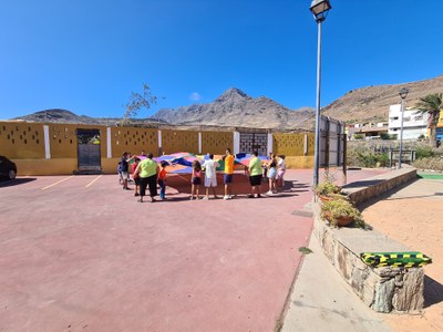Los participantes sujetan una sábana de colores