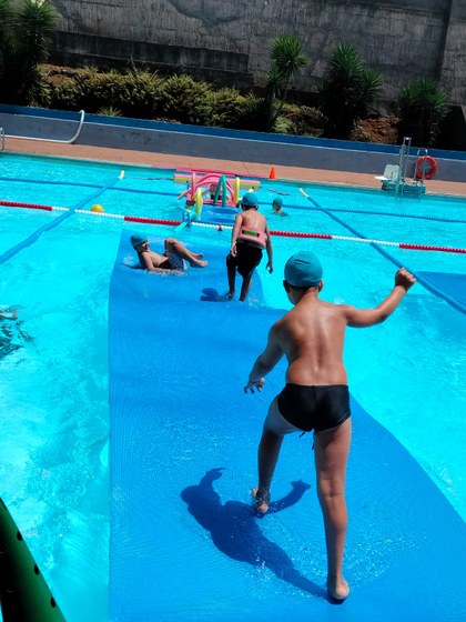 Participantes disfrutando de juegos en la piscina.