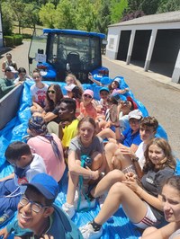 Grupo de participantes subidos en el remolque de un tractor