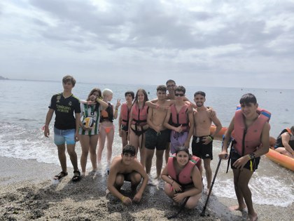 Grupo de participantes preparados para subir a las piraguas y tablas de paddle surf.