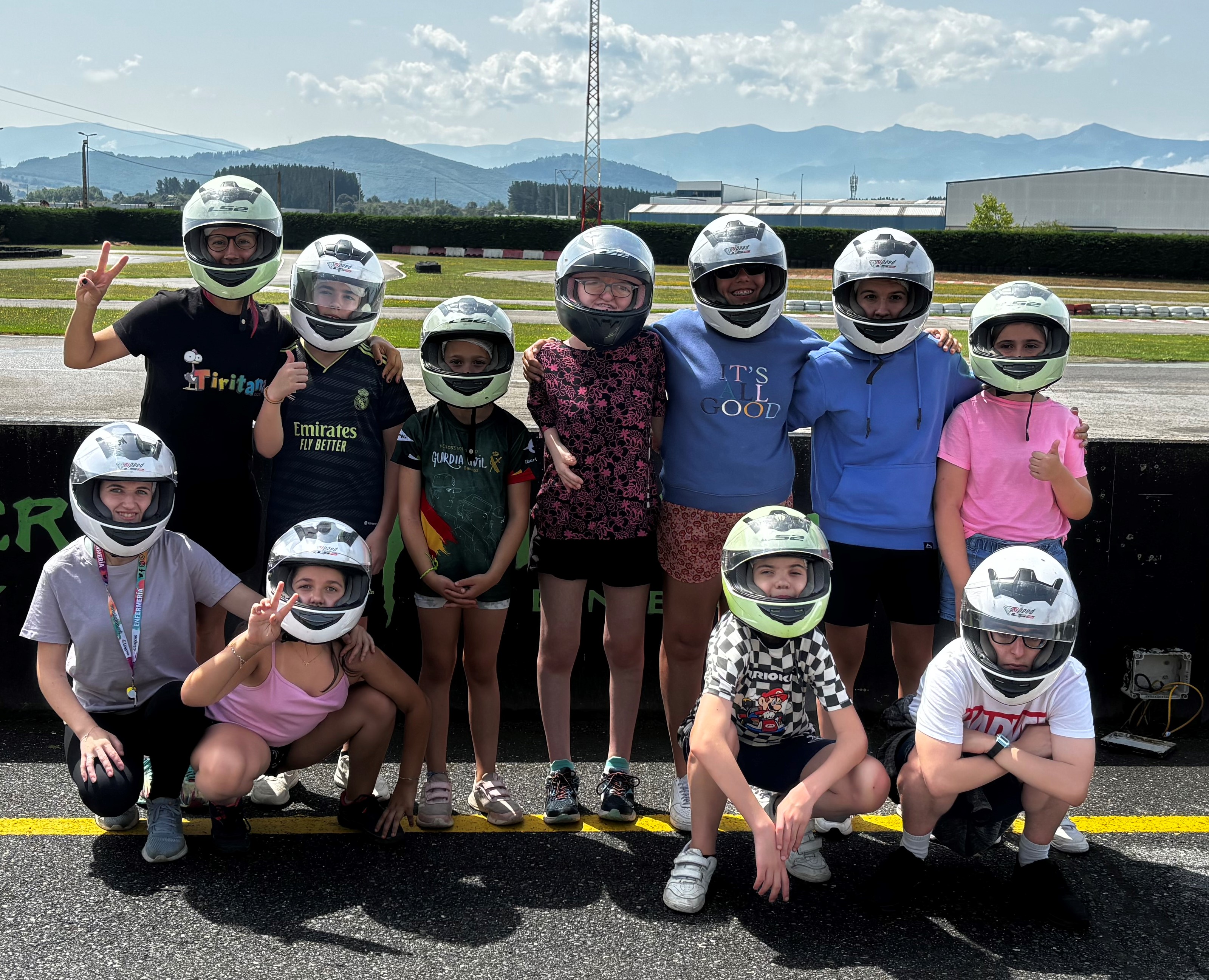 Grupo de participantes con los cascos puestos para montar en los Karts.