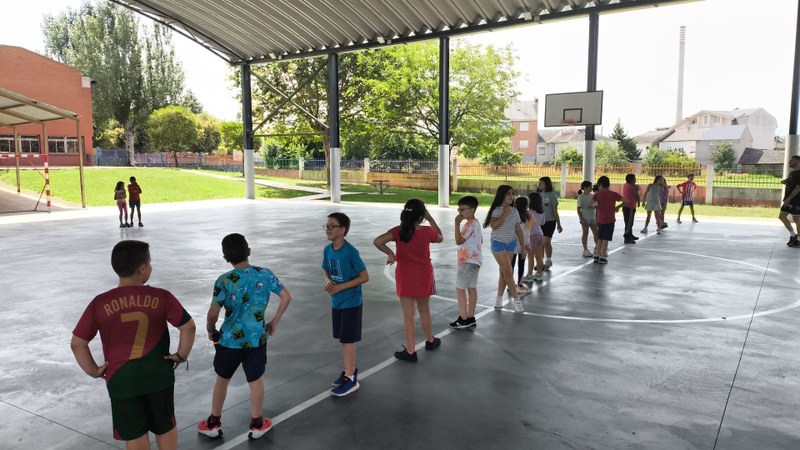 Participantes en la pista deportiva jugando al juego de la Muralla.