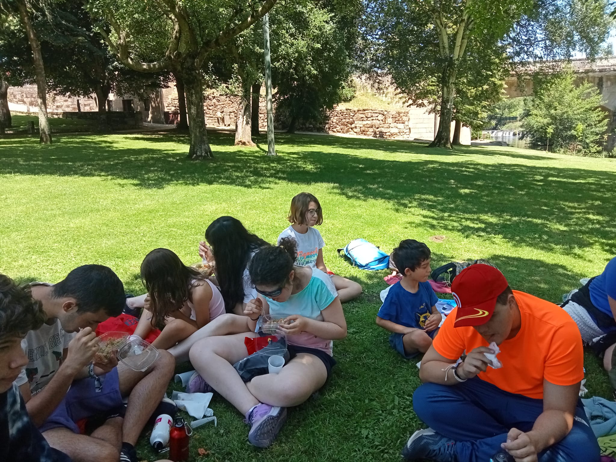 Participantes comiendo junto al río.