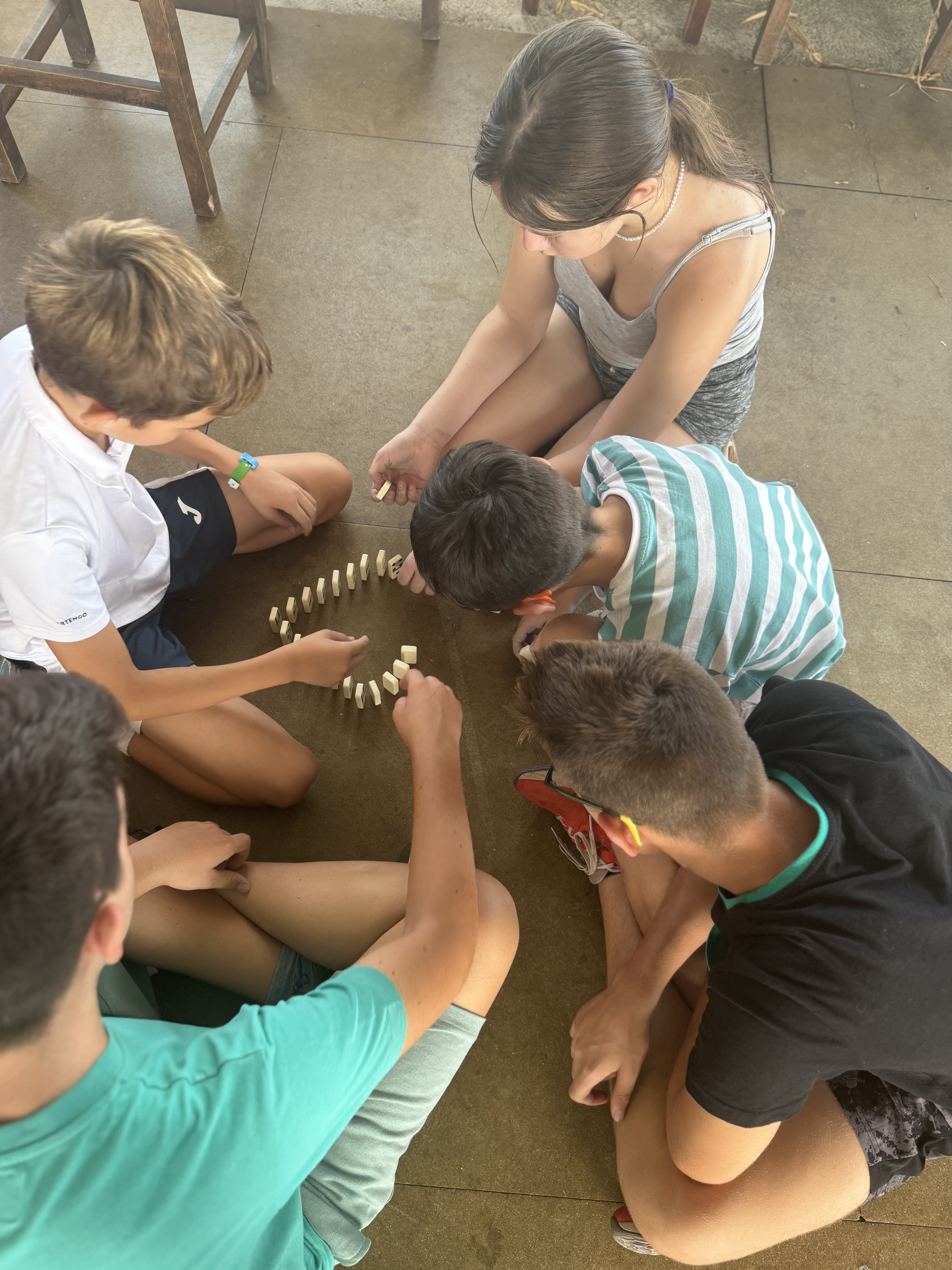 Participantes trabajando en equipo para formar una figura con piezas de dominó. 