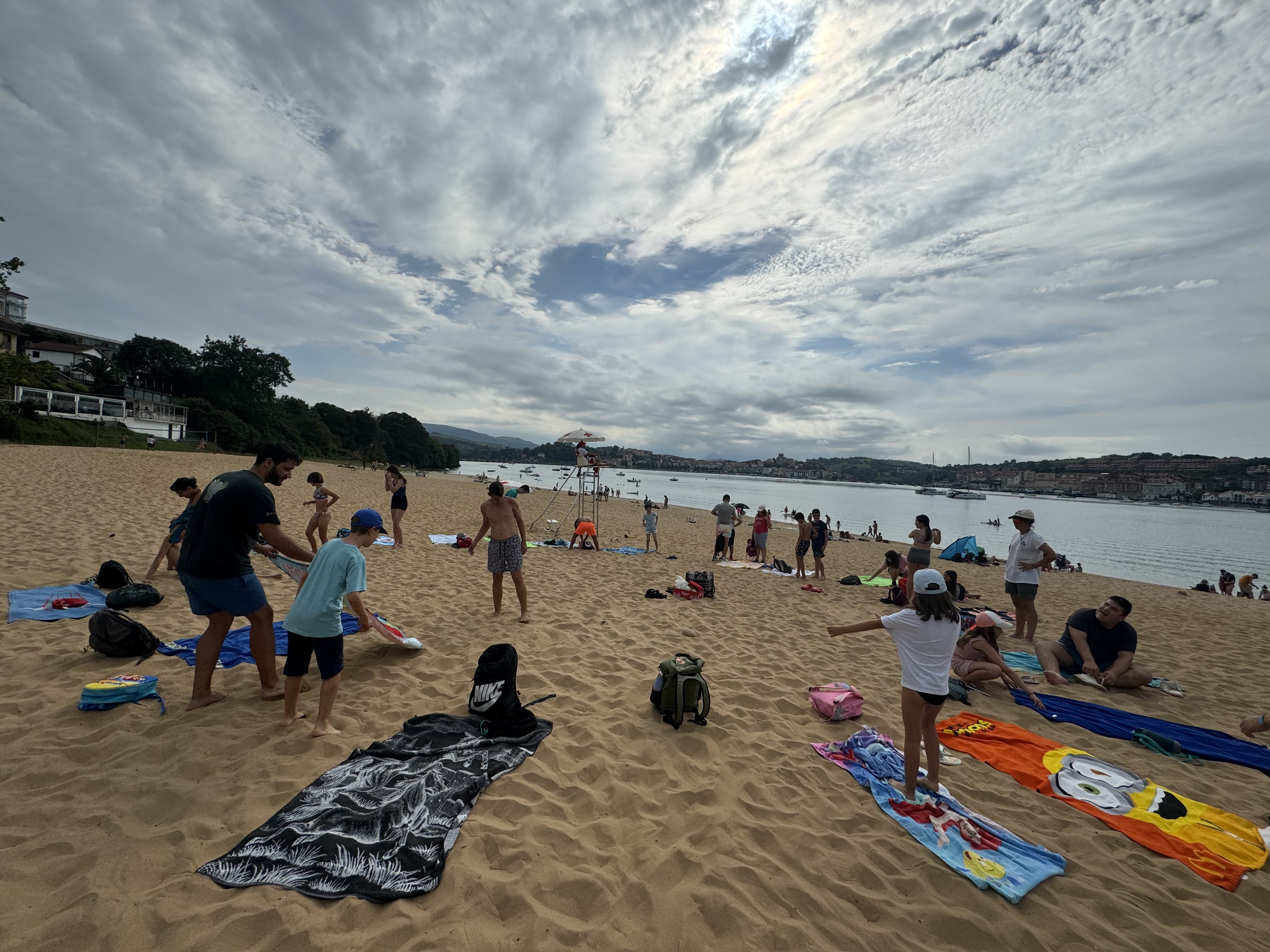 Participantes extendiendo sus toallas en la playa para disfrutar.