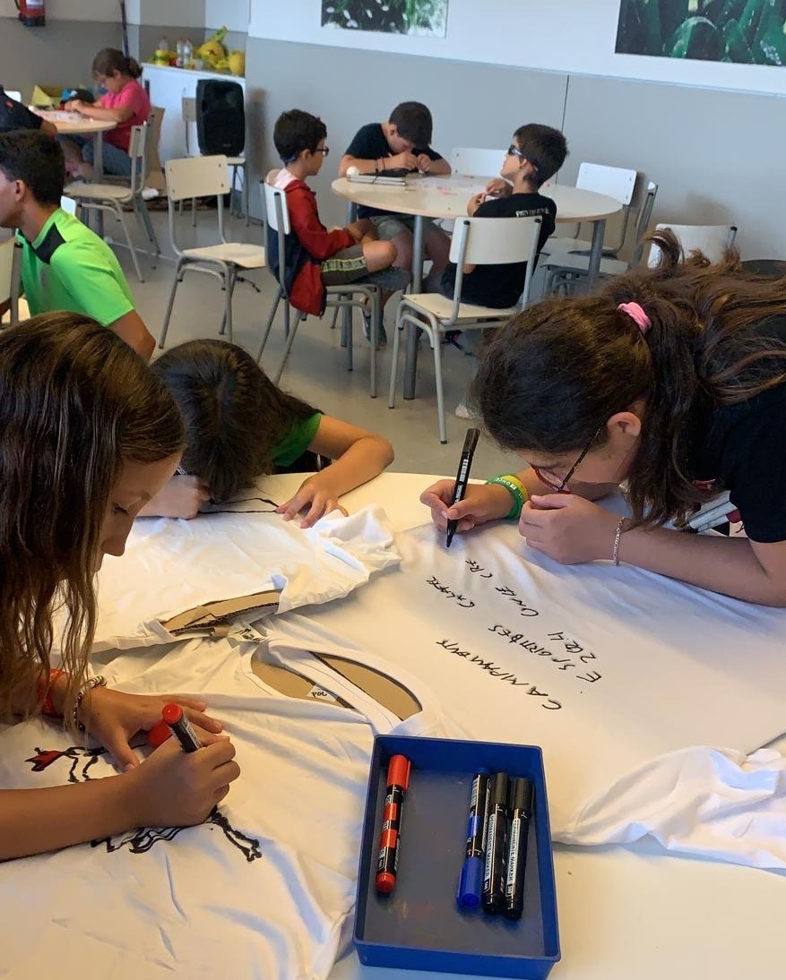 Participantes decorando y pintando camisetas