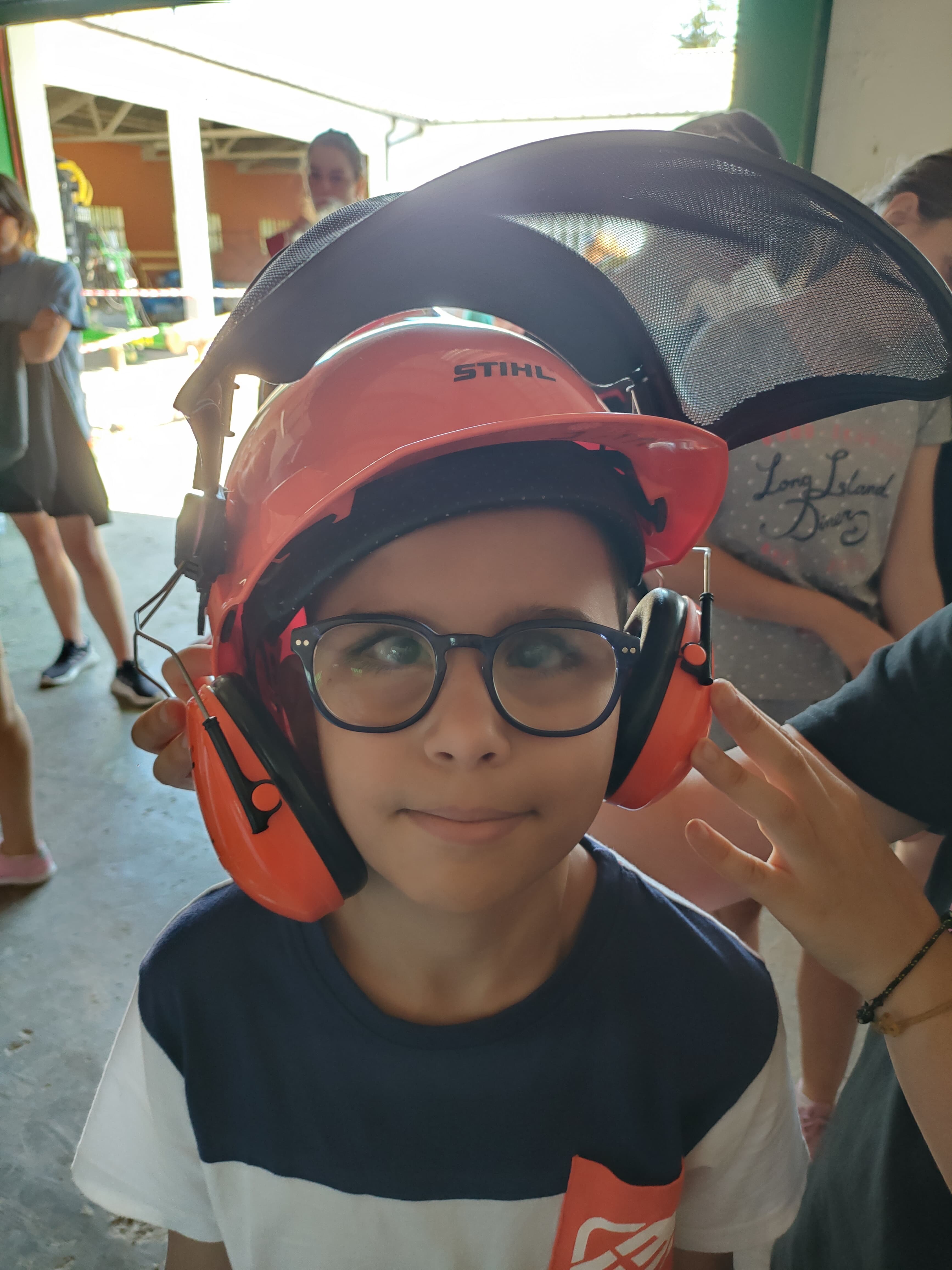 Participante protegido con casco y cascos insonorizados para la exhibición de motosierra