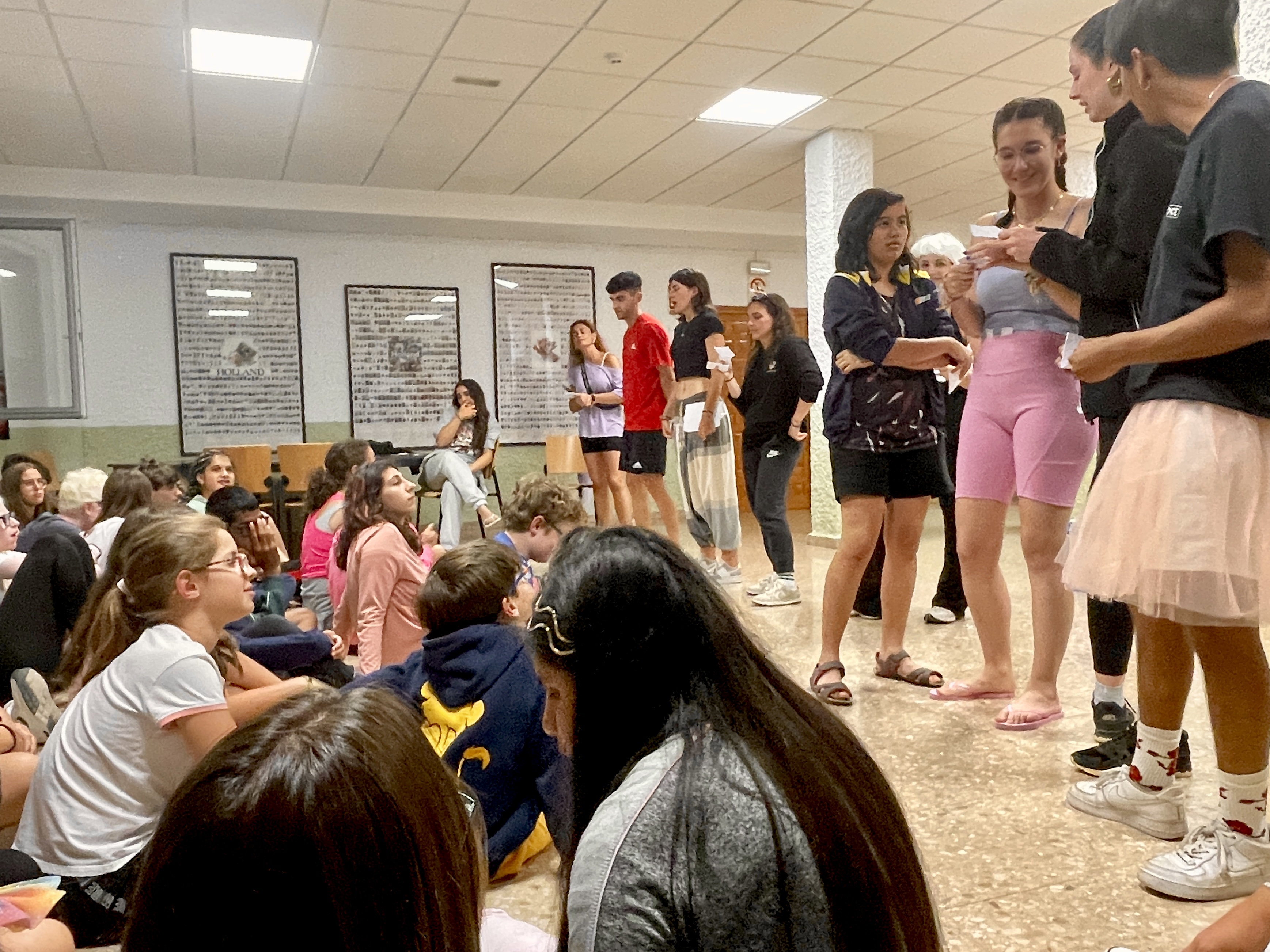 Participantes y monitores durante la velada nocturna leyendo las cartas del buzón del campamento. 