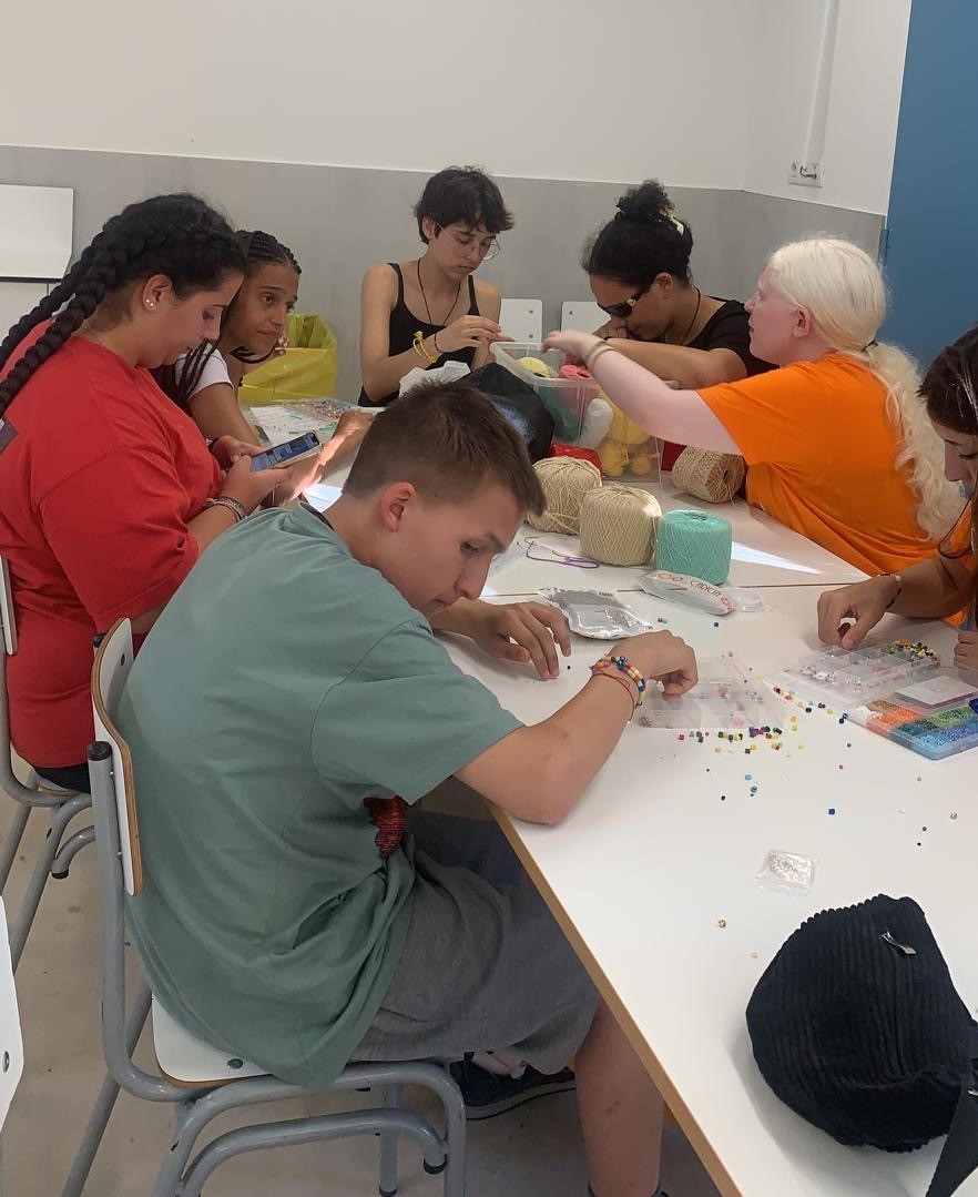 Participantes haciendo pulseras con abalorios