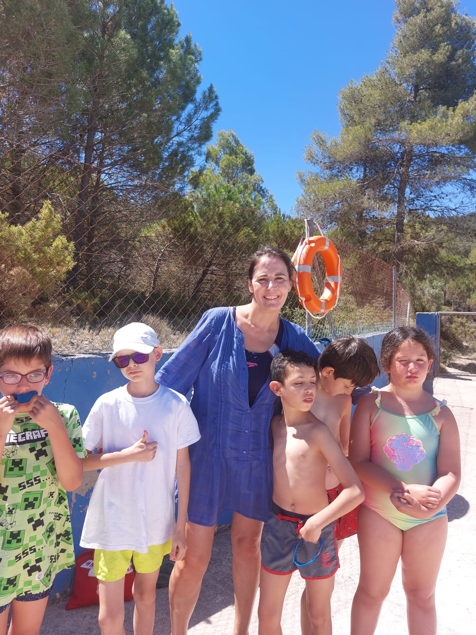 Participantes junto a una de sus monitoras en la piscina.