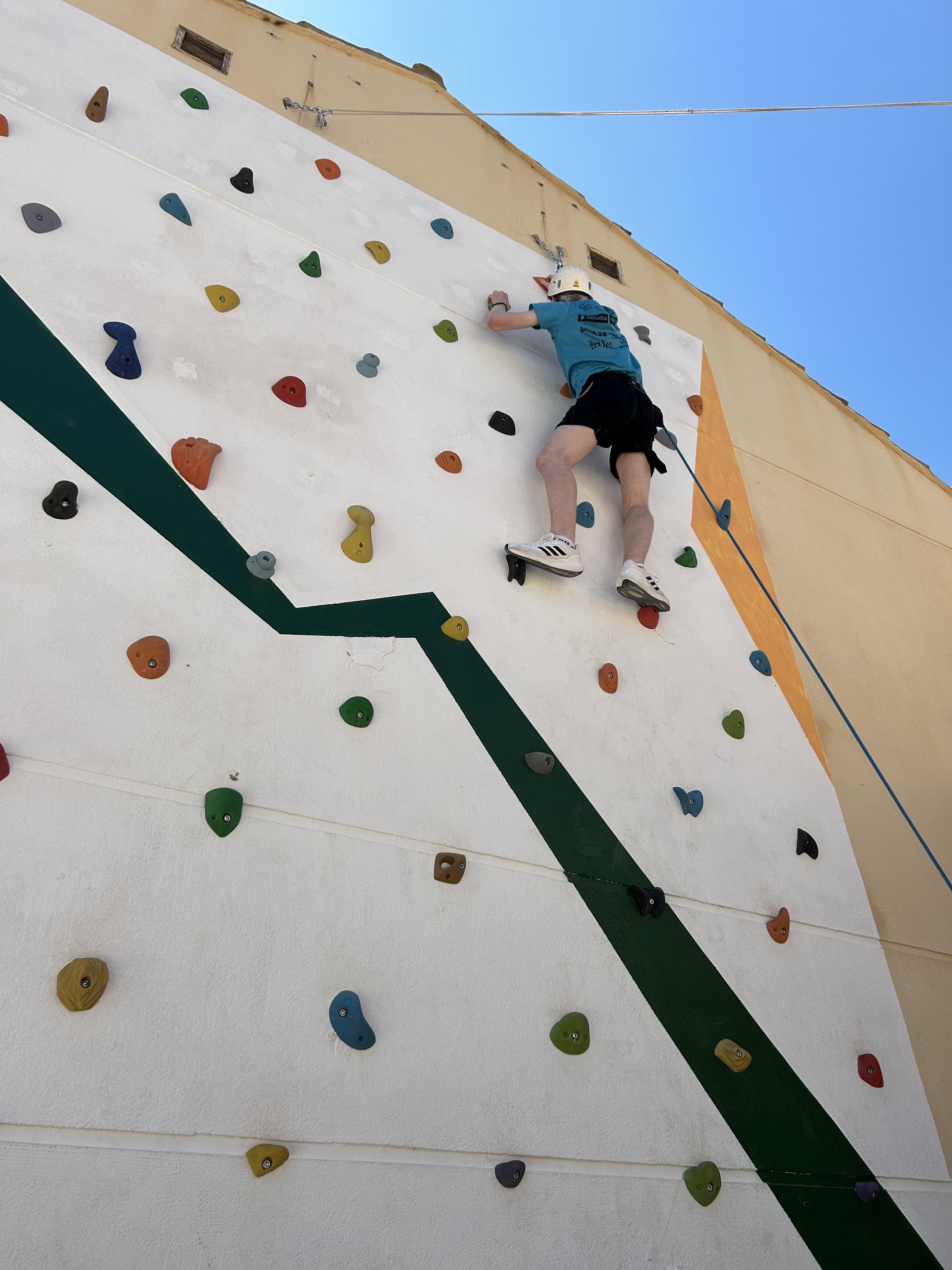 Participante escalando en el rocódromo.