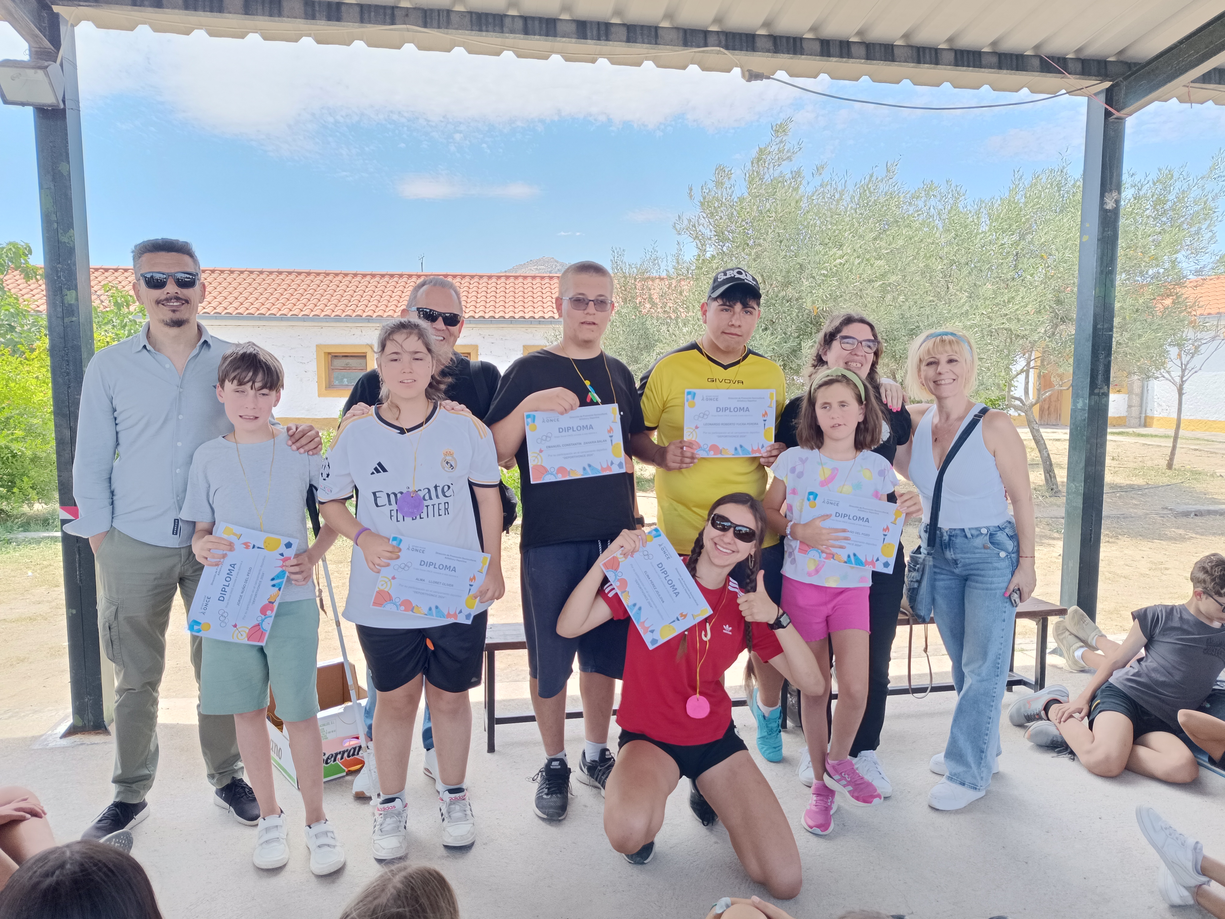 Participantes posando con sus diplomas y los miembros de la visita institucional.