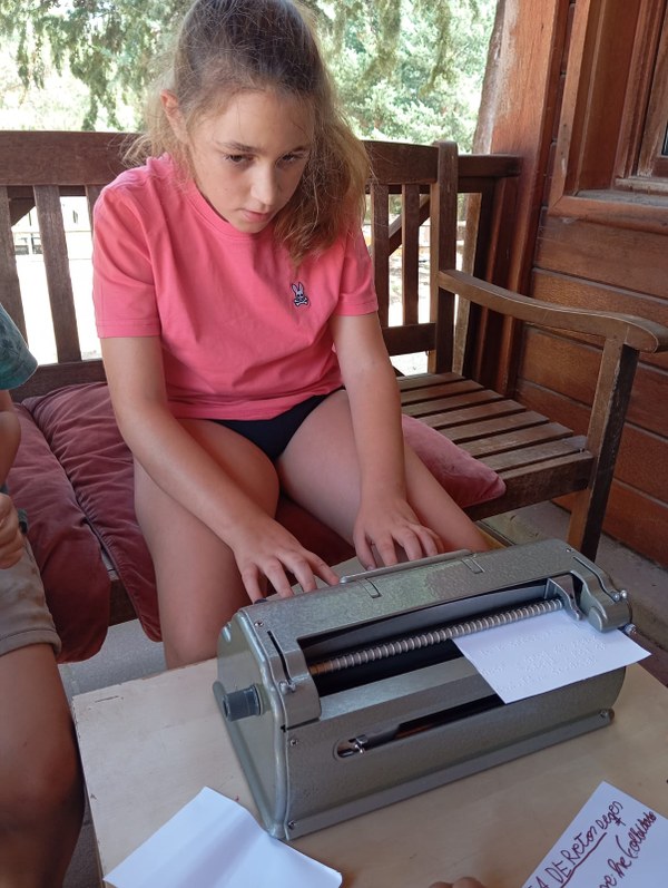 Una de las acampadas usando la máquina perkins para escribir una carta durante el tiempo libre.