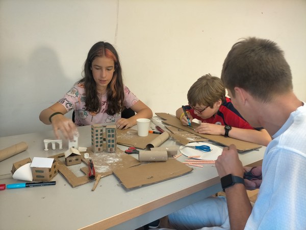 Participantes fabricando edificios a partir de materiales reciclados