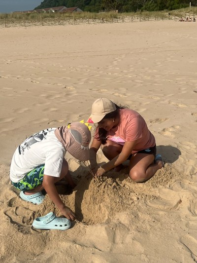 Dos participantes agachados jugando en la playa