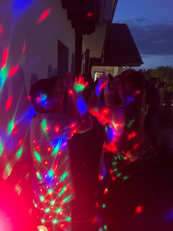 Campistas bailando durante la fiesta de despedida con luces de discoteca