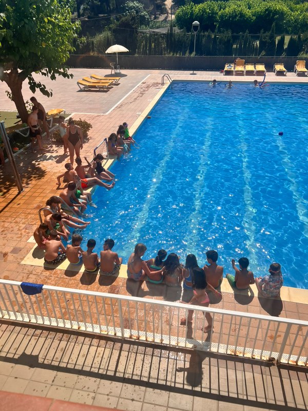 Participantes sentados en el borde de la piscina antes del baño