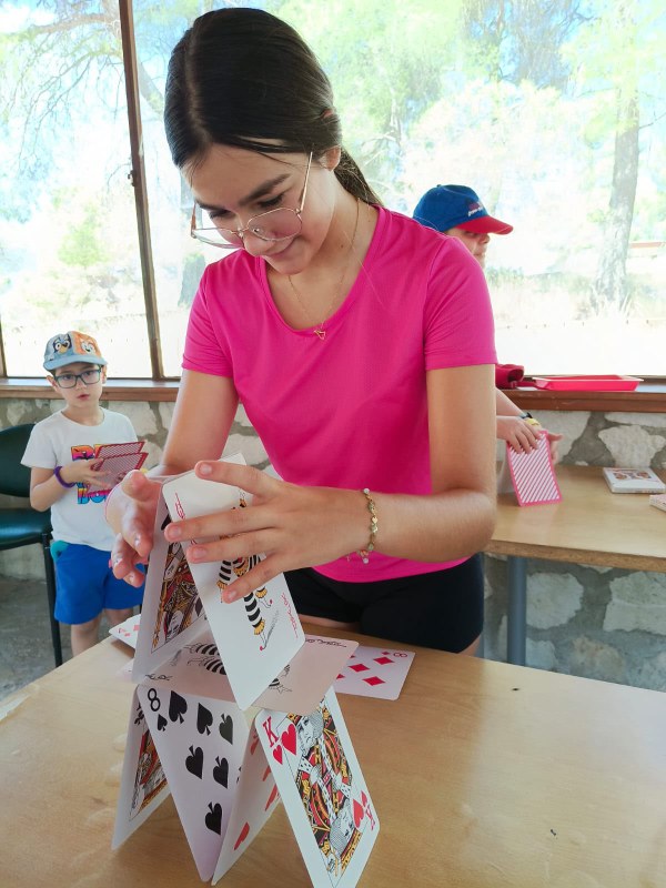 Participante construyendo una torre con cartas de poker grandes