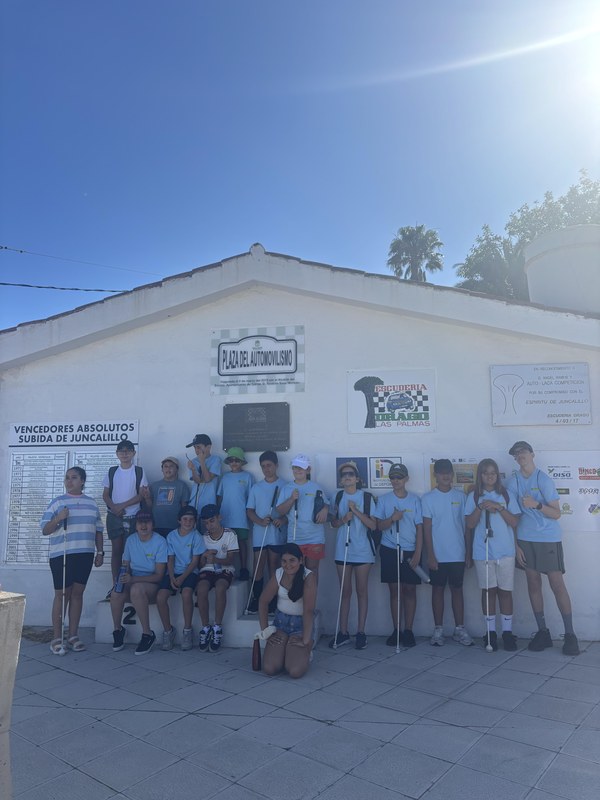 Foto grupal, participantes delante de la fachada de una casa baja de color blanco. 