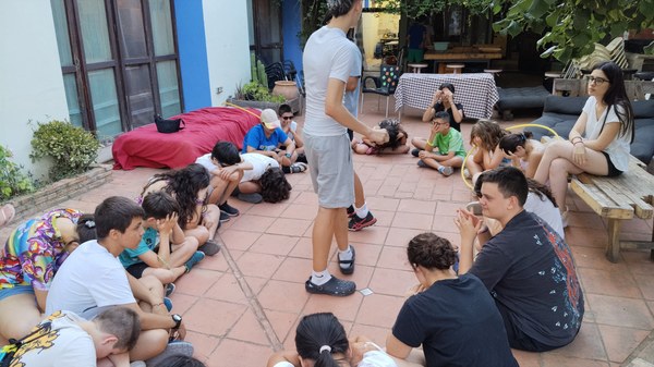 30.06 CIRCULO SUELO.jpg Participantes sentados en el suelo en círculo durante una actividad