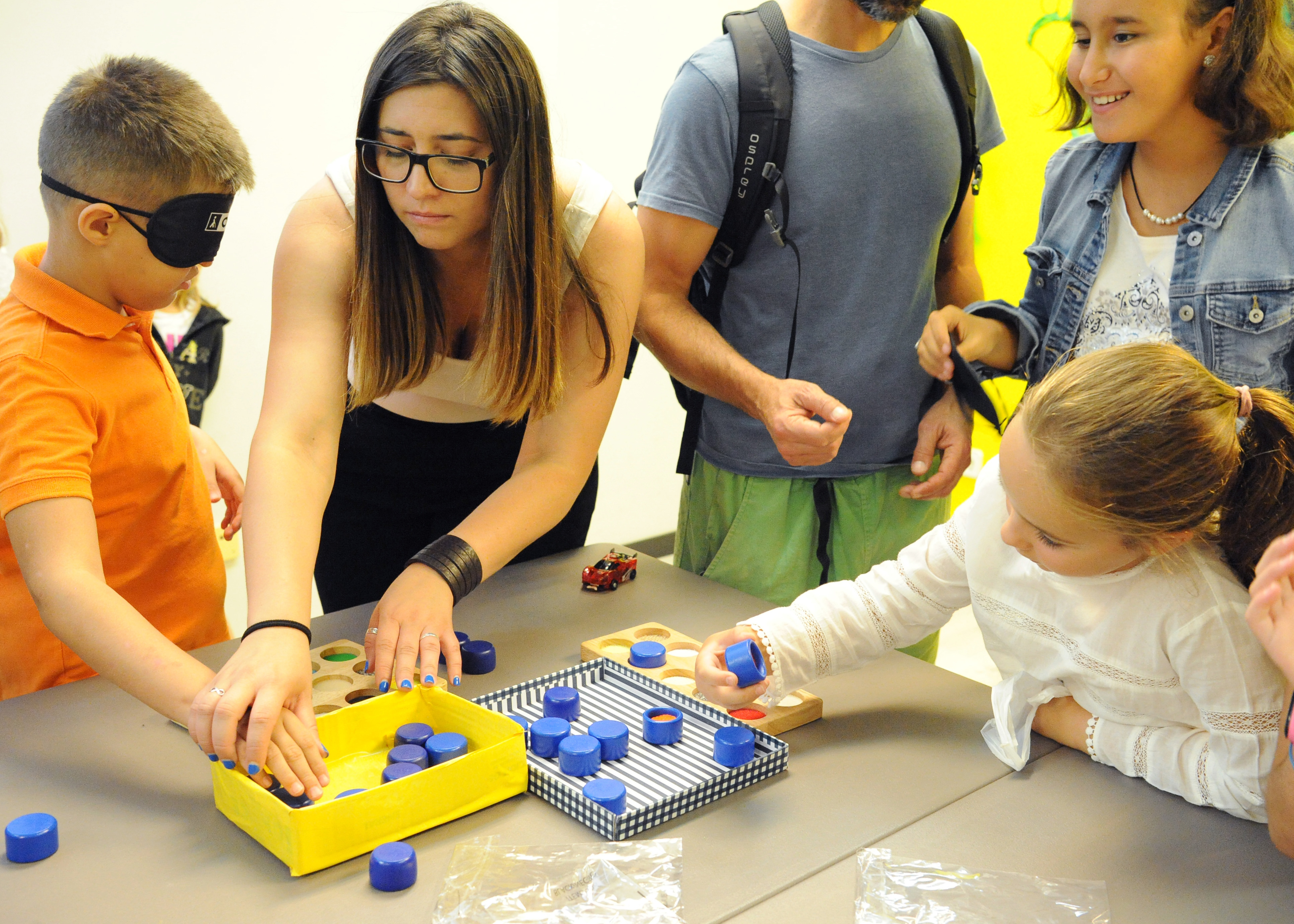 El grupo de participantes más jóvenes realiza juegos relacionados con los sentidos con una de las trabajadoras del museo