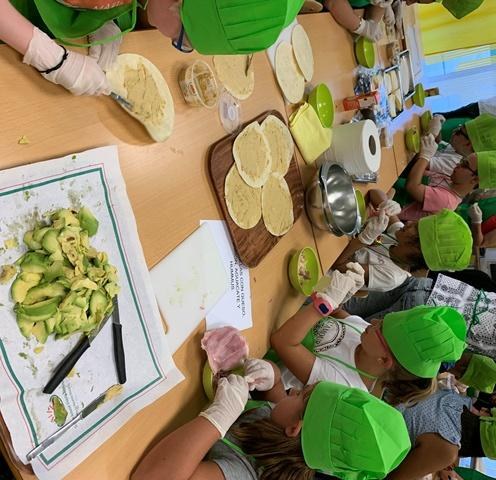 Los partipantes elaborando quesadillas con hummus y con aguacate