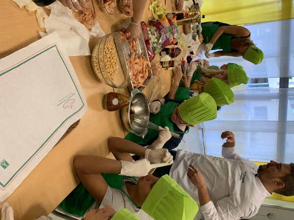 Un grupo elabora la receta de ensalada de salpicón de garbanzos y langostinos