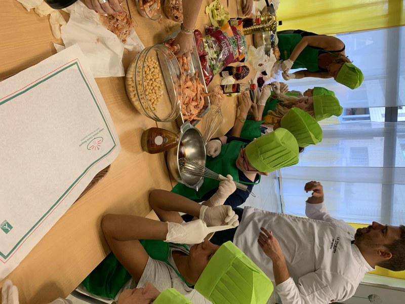 Un grupo elabora la receta de ensalada de salpicón de garbanzos y langostinos