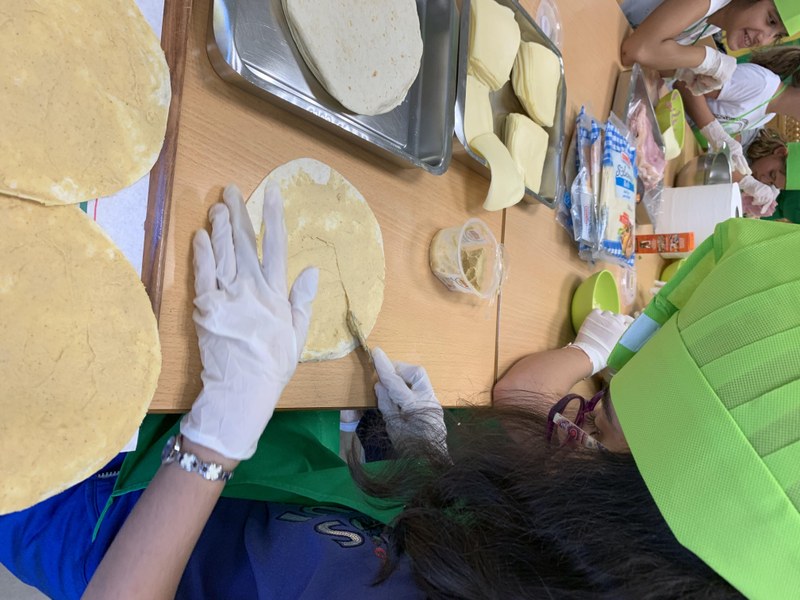 Una de las jóvenes unta una quesadilla con hummus