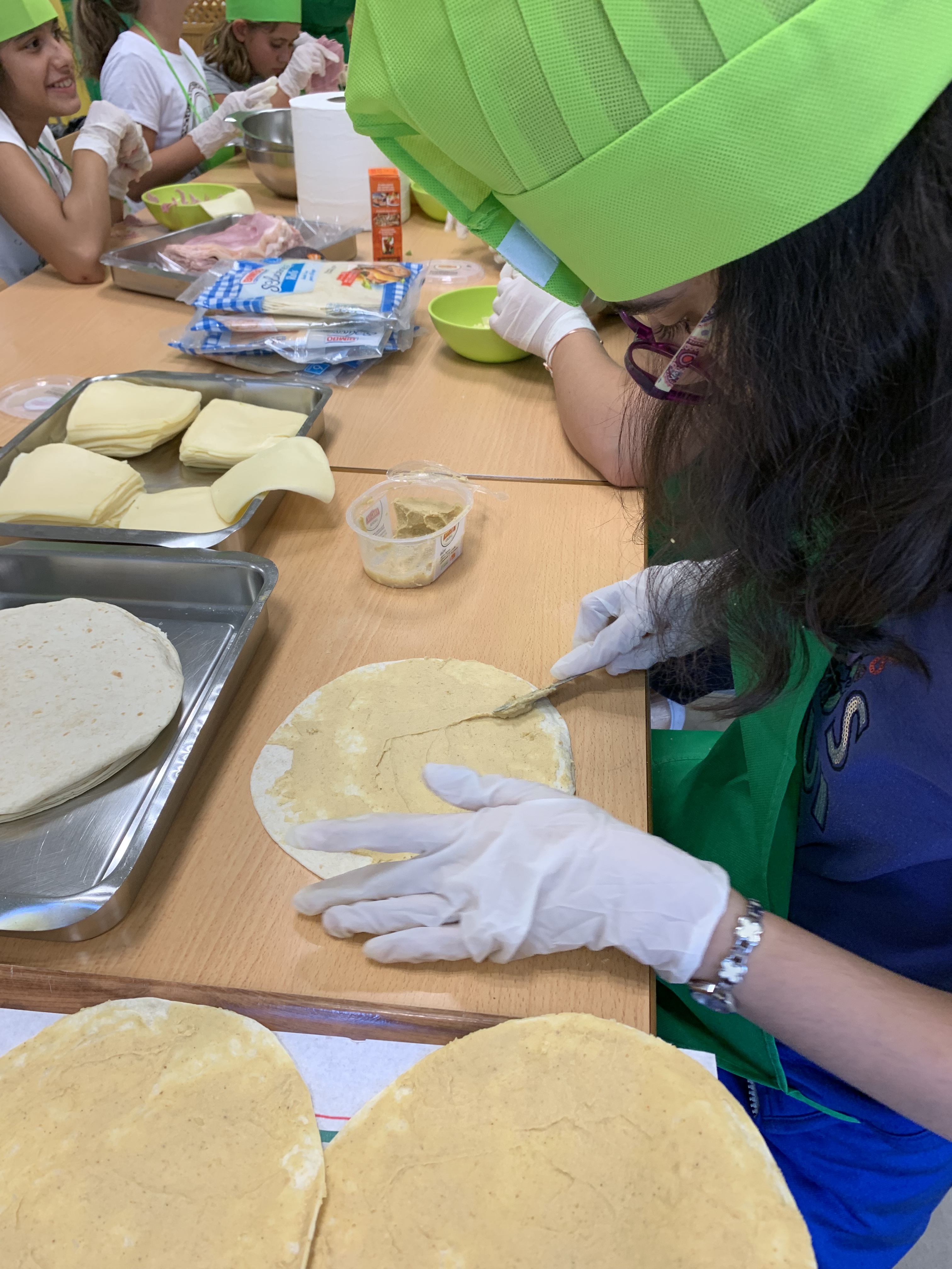 Una de las jóvenes unta una quesadilla con hummus